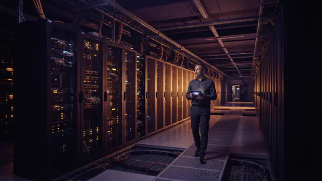 Row of glowing server racks inside an advanced computing data center facility