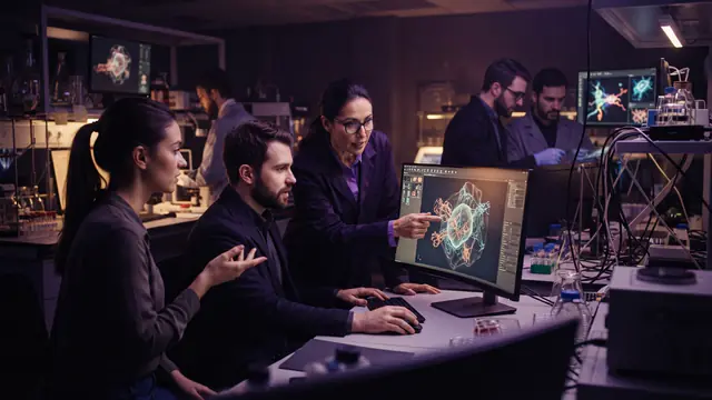 Scientists and computer engineers reviewing cellular data models inside a modern laboratory facility