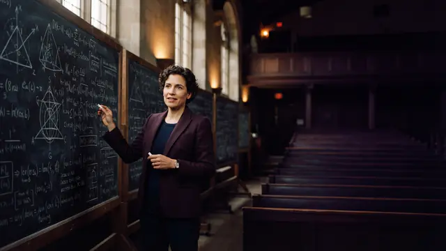 A mathematician standing in a lecture hall with dense mathematical equations and proof structures on blackboards
