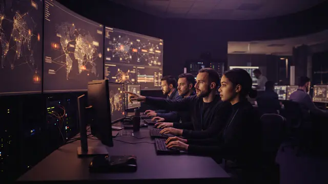 Cybersecurity operations center showing network monitoring maps and alert indicators